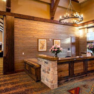 A warm and inviting reception area with a wooden desk and chandelier lighting.