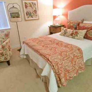 A cozy bedroom with orange-toned decor and patterned bedding.