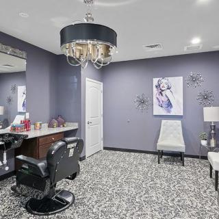 A stylish hair salon interior featuring a modern chandelier and barber chair.