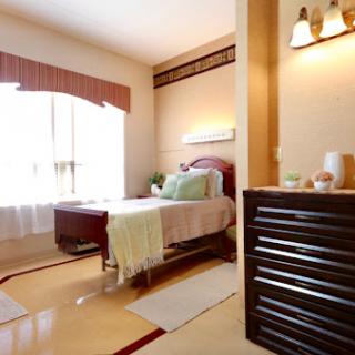 A cozy and well-lit bedroom featuring a stylish bed, warm colors, and elegant decor.