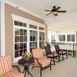 A cozy patio with comfortable seating and a ceiling fan.