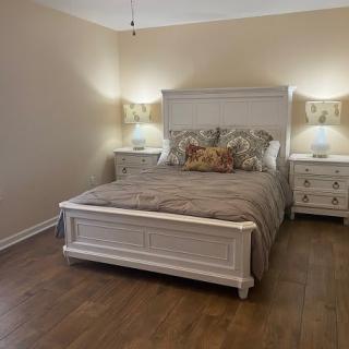A cozy bedroom with a wooden bed, nightstands, and lamps providing a warm ambiance.
