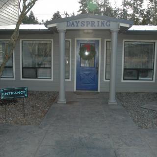 Front view of a building entrance with a blue door and pillars.