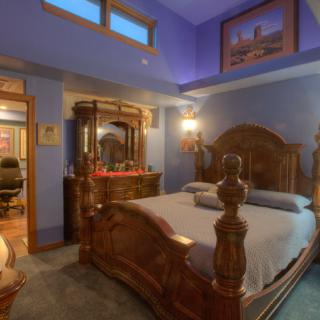 A luxurious bedroom with ornate wooden furniture and warm lighting.