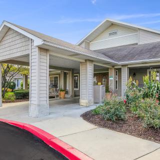 A residential building with a covered entrance and well-maintained landscaping.