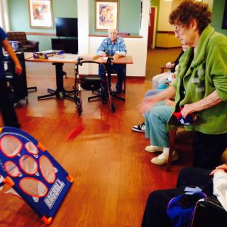 Elderly individuals engaging in a fun indoor game as part of a community activity.
