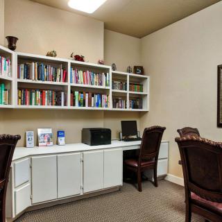 A tidy office space with bookshelves, a computer, and chairs.