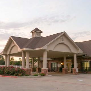 A welcoming building entrance surrounded by well-maintained landscaping.