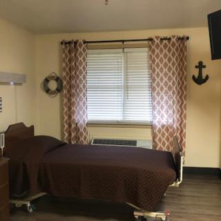 A cozy hospital room featuring modern furnishings and a warm color palette.