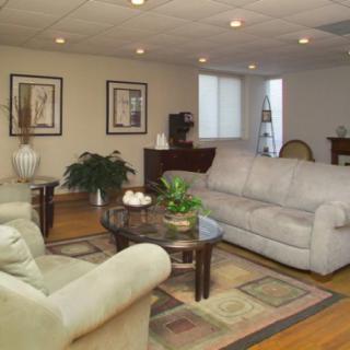 A cozy living room featuring comfortable sofas, a coffee table, and decorative elements such as plants and artwork.