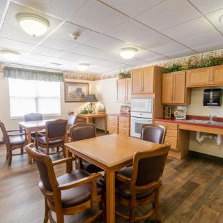 A cozy kitchen and dining area with wooden furniture and ample lighting.