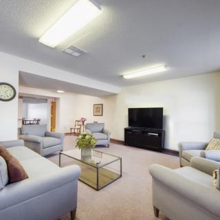 A modern living room with comfortable sofas, a large television, and a glass coffee table.