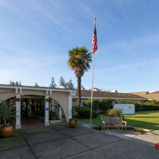 Entrance of a building with an American flag and palm tree in the foreground.