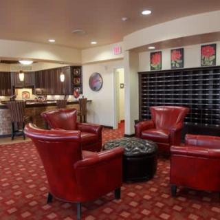 A cozy hotel lobby with red leather chairs and a warm, inviting atmosphere.