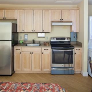 A modern kitchen with stainless steel appliances and wooden cabinets.