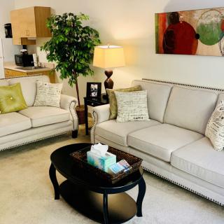A cozy living room featuring two sofas, a central coffee table, and modern decor elements.