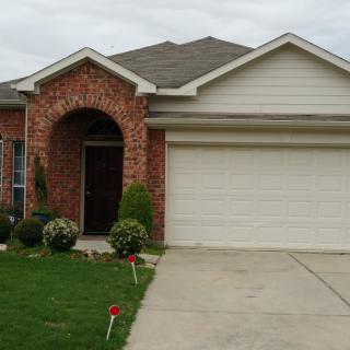 A suburban house with a brick exterior and attached garage.