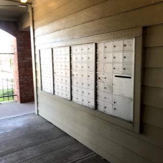 A row of mailboxes mounted on an exterior wall in a residential area.