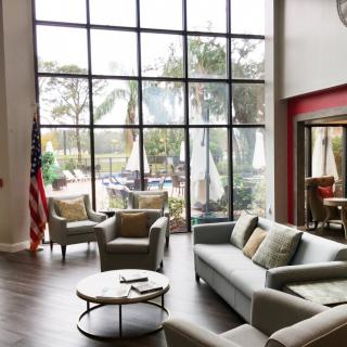 A modern lobby with comfortable seating and large windows offering a view of the outdoors.