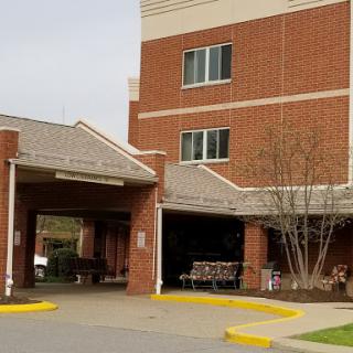 A brick medical facility with an inviting entrance and parking area.