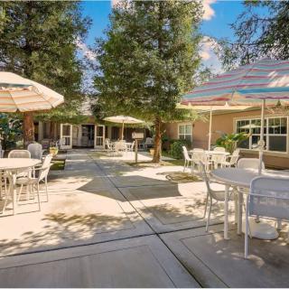An inviting outdoor patio with tables and umbrellas under a clear blue sky.