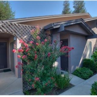 A charming house exterior with flowering plants and a lush garden.