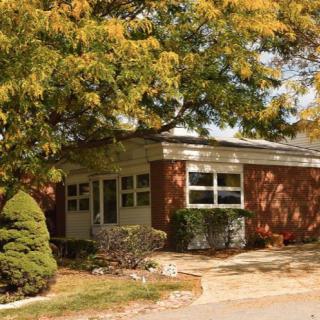 A quaint brick house surrounded by trees in autumn.