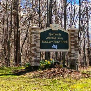 Entrance sign for an assisted living facility surrounded by nature.