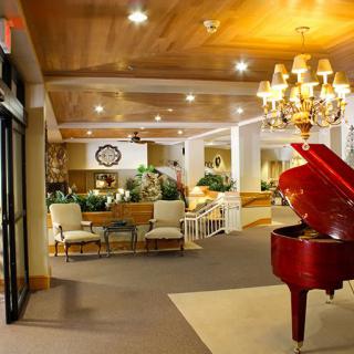 Elegant hotel lobby with a grand piano and chandelier.