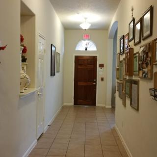 A well-decorated hallway with pictures on the wall leading to a wooden door.