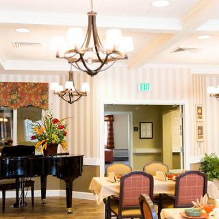 A well-decorated dining area featuring a grand piano and elegant chandeliers.