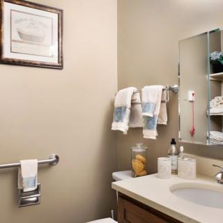 A neatly organized bathroom with towels, toiletries, and a mirror.