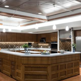 A spacious modern kitchen with wooden cabinets, a large island, and stainless steel appliances.