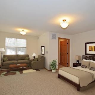 A cozy living and bedroom area featuring comfortable furniture and warm lighting.