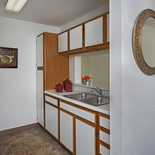 A small vintage-style kitchen with wooden cabinets and a sink.