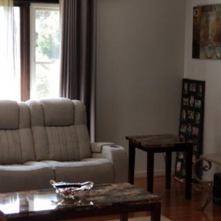 A cozy living room with a sofa, coffee table, and artwork on the walls.
