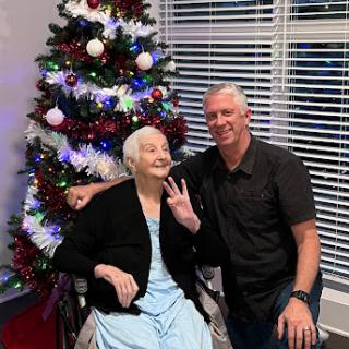 A joyful moment shared between family members in front of a beautifully decorated Christmas tree.