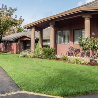 Single-story building with a well-maintained lawn and garden.