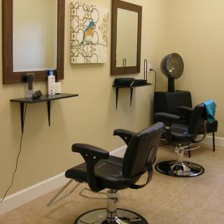 A clean and organized hair salon with styling chairs and mirrors.