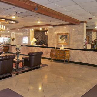 A well-furnished hotel lobby with a reception desk and seating area.
