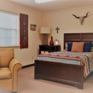 A cozy bedroom with rustic decor and comfortable furnishings.