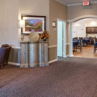 A welcoming lobby area with elegant decor and comfortable seating, leading to a dining area.