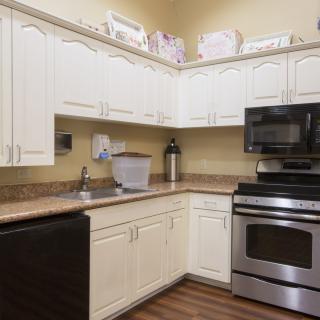 A modern kitchen with white cabinets and stainless steel appliances.
