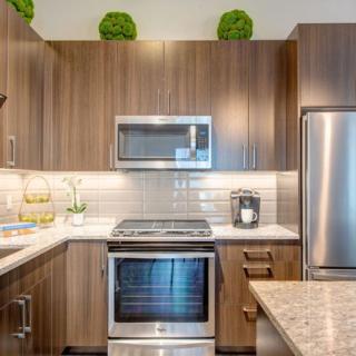 A modern kitchen with wood cabinets and stainless steel appliances.