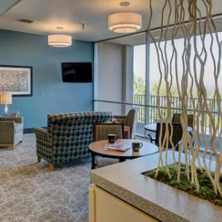 A modern lounge area designed for comfort and relaxation, featuring blue walls and stylish furniture.