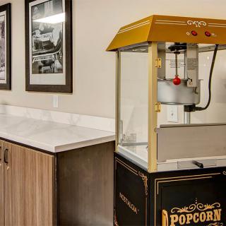 A popcorn machine on a countertop in a room with framed pictures on the wall.
