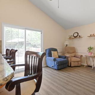 A cozy living room with comfortable seating and a view of the outdoors through a sliding glass door.
