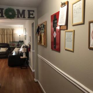 A cozy hallway leading into a living room, adorned with picture frames and artwork on the walls.