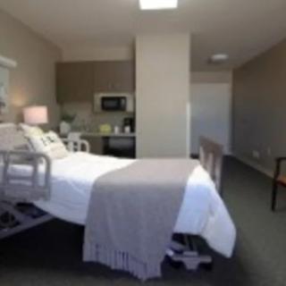 A clean and modern hospital room with a bed and essential equipment.