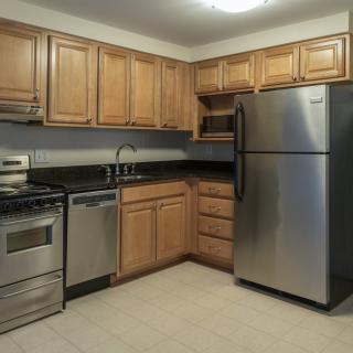 A modern kitchen with stainless steel appliances and wooden cabinets.